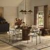 Dining room space with wooden table and four chairs beneath Fiorella Scalloped Chandelier lighting the area