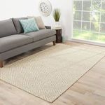 Living room setting showing rug under gray sofa with blue patterned pillow by large window