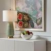Hive Lamp on white sideboard next to bowl of green and red apples beneath framed botanical artwork