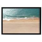 Aerial view of ocean waves gently meeting a sandy beach, framed in a sleek black border