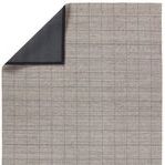 Back corner of rug folded to reveal smooth, dark gray non-slip backing