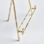 Close-up rear view of easel legs and support bar highlighting bamboo-style texture and shape
