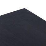 Close-up of black wash desk surface showing natural wood grain texture on the Tilda top