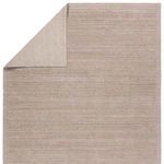 Curled edge showing the reverse side flatwoven weave and color consistency of the light brown rug