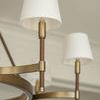 Close-up of white tapered glass shade on brass and leather arm of chandelier