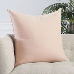 blush pillow positioned on beige couch with natural lighting and soft shadows
