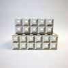 Straight-on view of smaller box centered atop larger box showing alignment of raised bone cubes