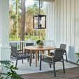 Wider porch perspective showing hanging lantern, white railing, and seating arrangement around teak table
