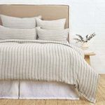 Front view of Blake duvet cover and matching shams on bed with tan upholstered headboard and dried eucalyptus on side table