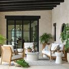 Outdoor seating area with multiple Savannah chairs and sofa under black timber pergola