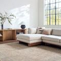 Maria Brown/Ivory Elena rug styled in a bright living room with beige sectional sofa and wooden shelves