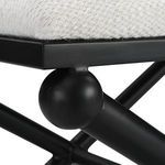 Close-up detail of black iron spherical joint connecting bench legs and frame