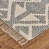 Close-up of rug corner showing fringe detail and texture on wooden floor