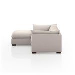 Close-up side angle displaying layered cushions and boxy armrest with textured stone fabric