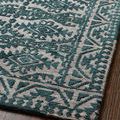 Angled close-up of rug edge showing clean finish and distinct raised teal pattern