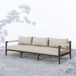 Sherwood sofa displayed outdoors on stone patio with soft shadows and green plants visible