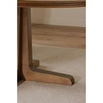Close-up of one leg of Charles Dining Table resting on light carpet flooring