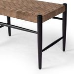 Downward angle on woven leather strap seat and black wood posts of Wyatt Bench