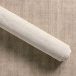 Rolled rug showing creamy fabric backing against uniform taupe rug top surface