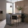 Two graphite leather bar stools styled at a kitchen island with pendant lights and wood slat wall.