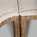 Detail shot of cushioned seating corner and rattan armrest highlighting natural material texture
