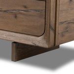 Base corner close-up displaying leg design and wood texture of media console