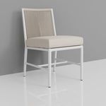 Sabbia chair shown from a frontal angle against a gray wall with reflective white floor