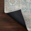 Rug corner folded back to reveal solid black non-slip backing material