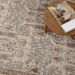 Close-up view of rug pattern beneath wooden coffee table with open book on top