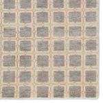 Detail view of the rug’s surface showing geometric squares and subtle tonal variations in gray and ivory