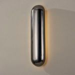 wall sconce illuminated with ambient warm light casting subtle gradient on beige wall
