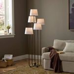Tulane floor lamp placed in corner of living room beside beige sofa and rug