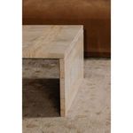 Close-up side view of Rosa coffee table in living room showing corner and marble strip detail