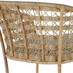 Close-up of woven natural rattan pattern on stool back with visible linen cushion.