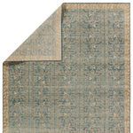 Rug corner folded over reveals backside with muted color and pattern