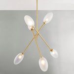 Chandelier illuminated with warm light, suspended in front of gray wall and white ceiling corner