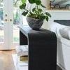 Side angle showing console table with indoor plant and visible hardwood floor by glass French doors