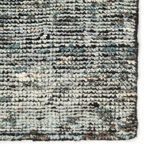 Close-up of textured wool fibers highlighting the blend of gray, black, and cream colors