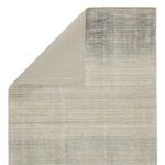 Top view with folded corner revealing plain woven backing and stitched edges in neutral tones