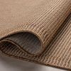 Partially rolled Merrick Oatmeal rug emphasizing the pliability and thickness of the polypropylene material.