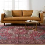 Rust-colored leather sofa and wooden coffee table on top of the Gloria Medallion rug
