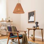 Living room scene with the pendant hanging over mid-century armchair and small table with decor