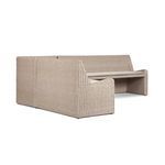 Profile view of one full bench side with fabric cushion on woven rattan base
