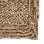 Close-up of jute rug's thick braided texture and detailed bordered corner