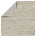 Back side of rug showing solid neutral fabric backing with folded corner