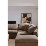 Terra Condo Ottoman styled in a living room next to a sectional with contemporary artwork in background