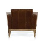 Back view displaying leather upholstery with vertical seams and slightly tapered wooden legs.