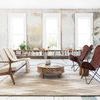 Rug styled in a bright living room with mid-century sofa, butterfly chairs, and round wooden coffee table