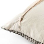 Close-up of pillow corner with exposed zipper on cream fabric back and woven patterned front
