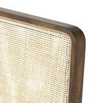 Close-up focus on bronzed iron front leg with oak frame and cream seat